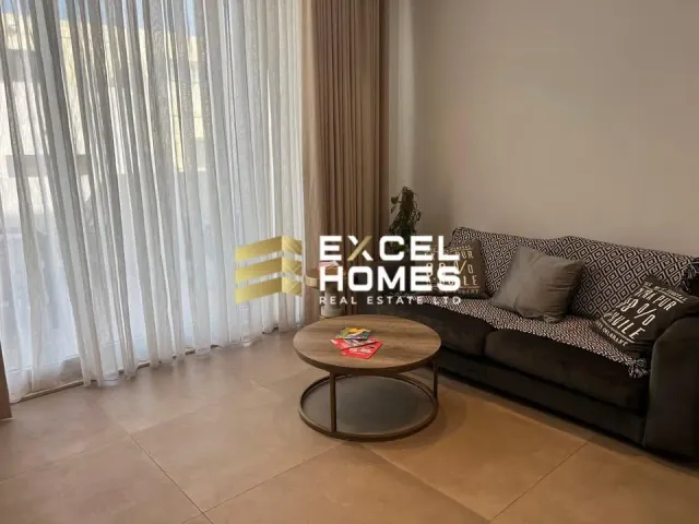 a living room with a couch, coffee table and a window 