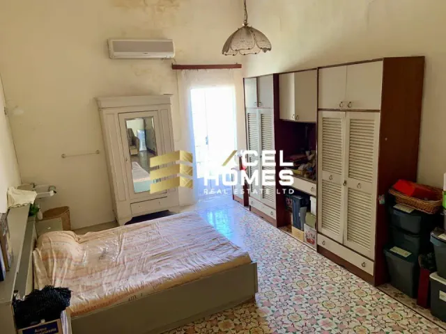 a bedroom with a bed, a dresser, and a television