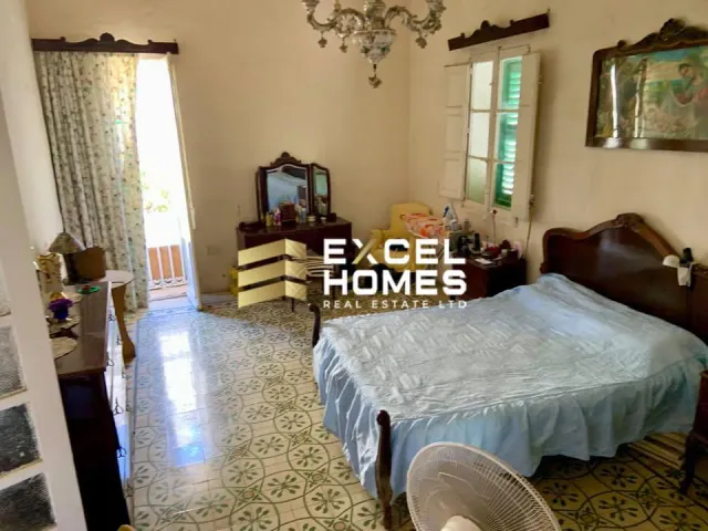 a bedroom with a bed, chair, and a table