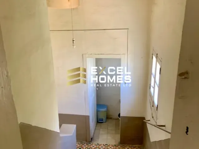 a bathroom with a toilet and a stairway