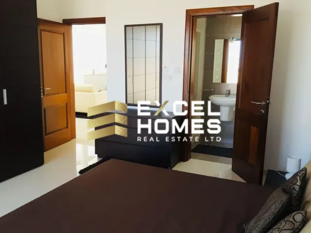 a bedroom with a bed, desk, and a television