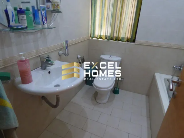 a bathroom with a toilet, sink, and mirror