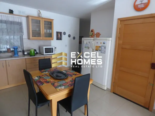 a kitchen with a table, refrigerator, microwave and a refrigerator