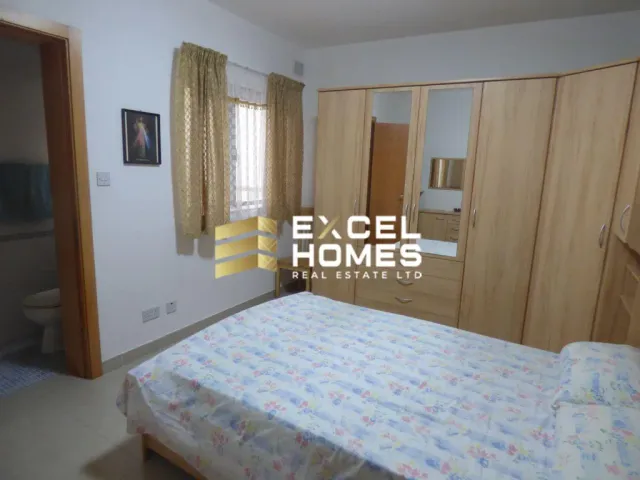a bedroom with a bed, a dresser and a window