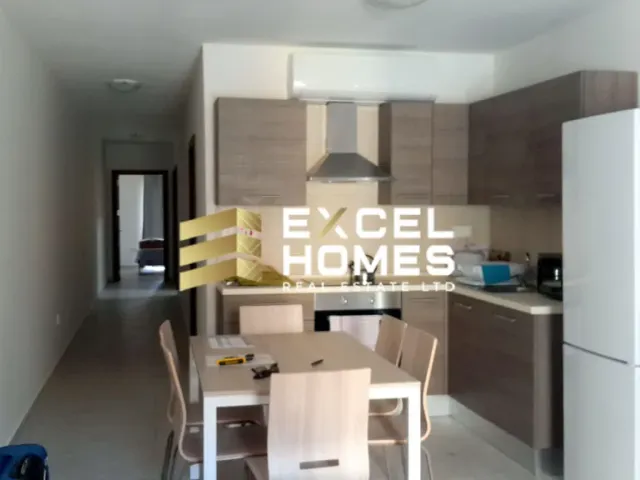 a kitchen with a refrigerator, microwave, and a table