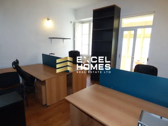 a room with a desk, chair, and a window