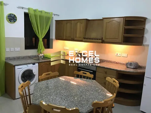a kitchen with a table, chairs, and a refrigerator