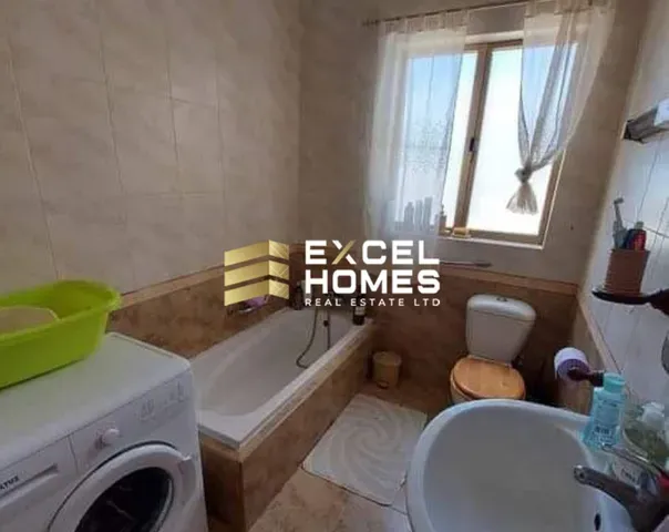 a bathroom with a toilet, sink, tub and window