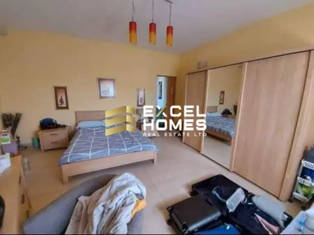 a bedroom with a bed, desk, and a computer