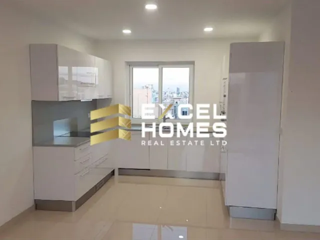 a room with a white wall and a white refrigerator