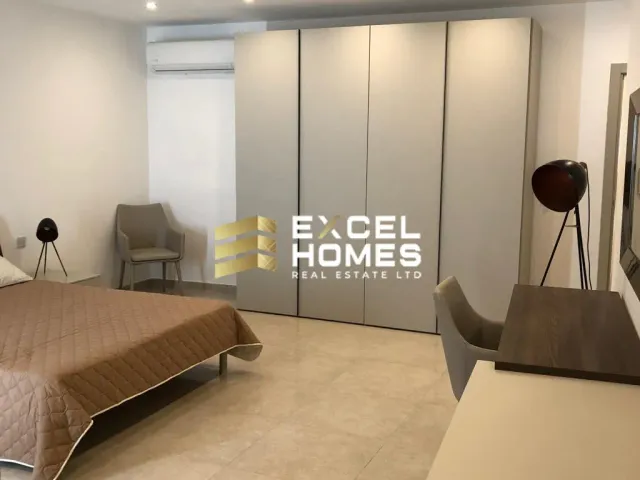a hotel room with a bed, desk, and a mirror 
