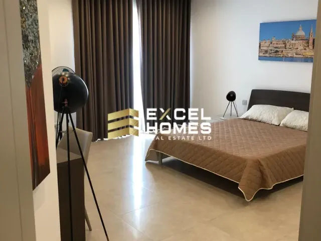 a person standing in a room with a bed and a desk 