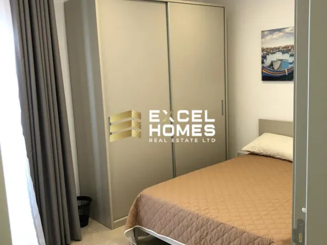 a bedroom with a bed, desk, and mirror 