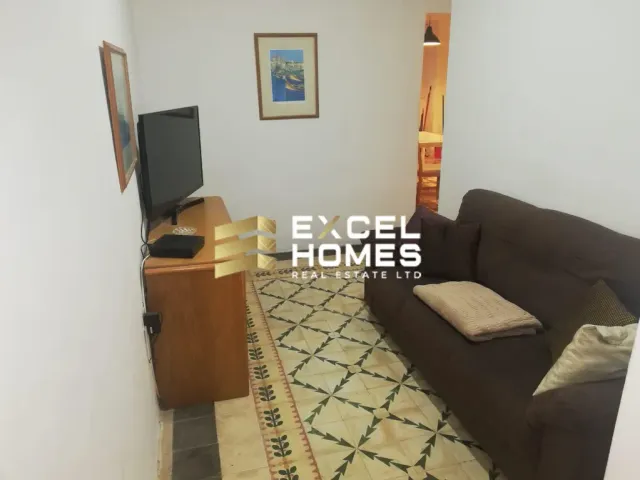 a living room with a couch, television and a rug 