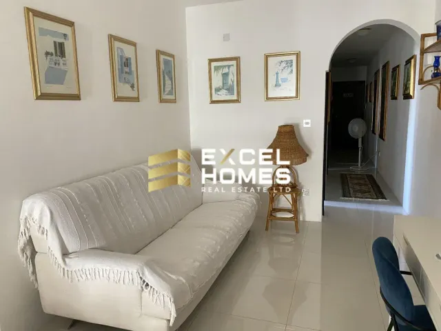 a living room with a couch, chair, and a lamp