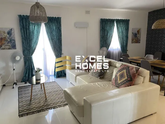 a living room with a couch, chair, and a window