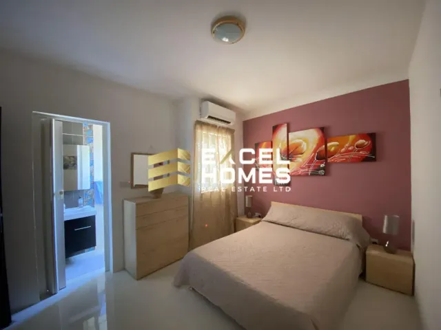 a bedroom with a bed, a dresser, and a television