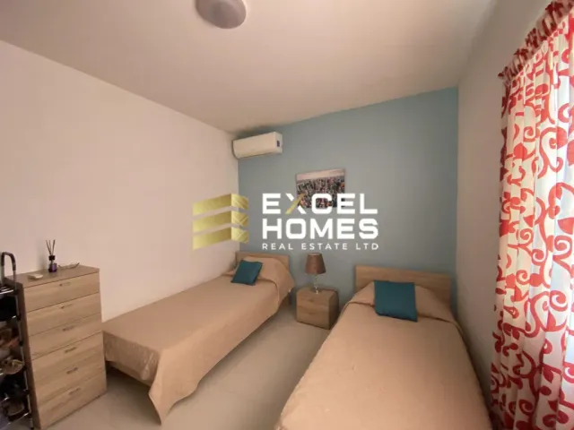 a bedroom with a bed, desk, and a lamp