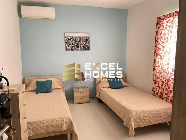 a bedroom with a bed, desk, and a television