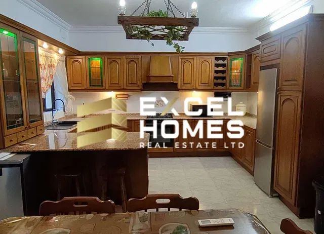 a kitchen with a refrigerator, sink, and a counter top