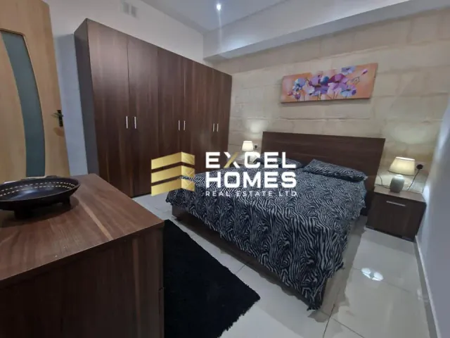 a bedroom with a bed, desk, and a lamp