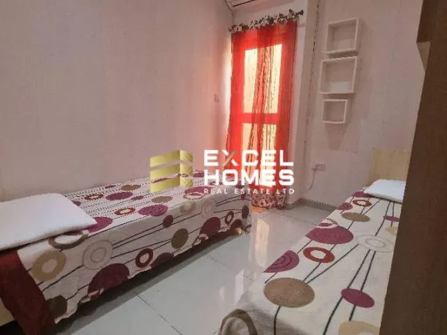 a bedroom with a bed, a table, and a window