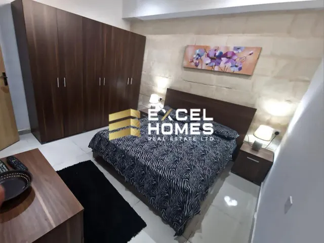 a bed room with a bed, desk, and a painting