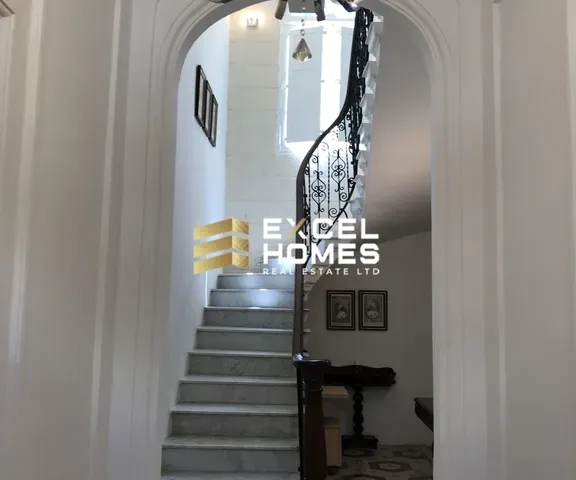 a hallway with a stairway leading to a stairway with a staircase