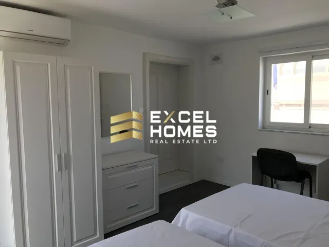 a bedroom with a bed, dresser, and a window