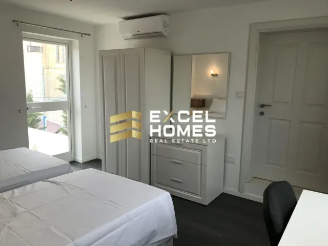 a bedroom with a bed, dresser, and a window