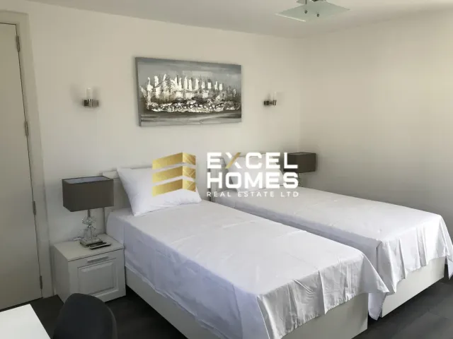 a hotel room with a bed, desk, and a television