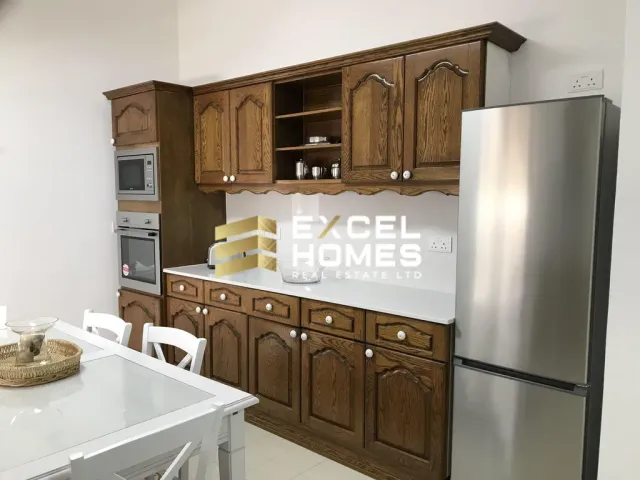 a kitchen with a refrigerator, sink, and cabinets
