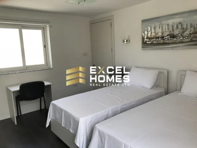 a bedroom with a bed, desk, and a window