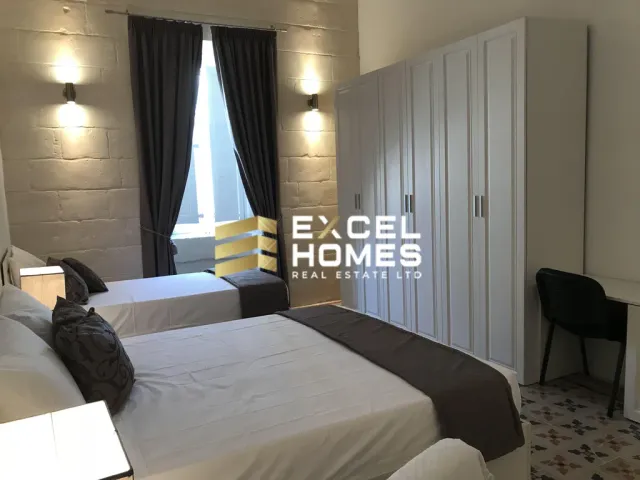 a bedroom with a bed, a desk and a lamp