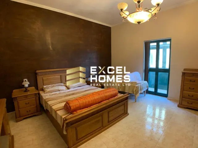 a bedroom with a bed, a desk, and a lamp