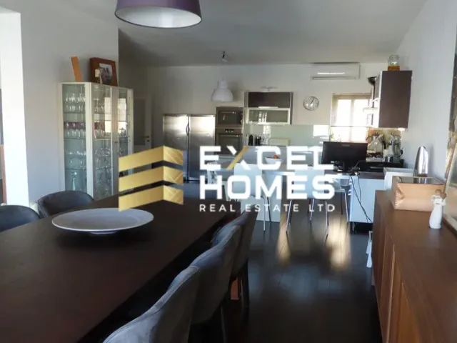 a kitchen with a table, chairs, and a refrigerator 