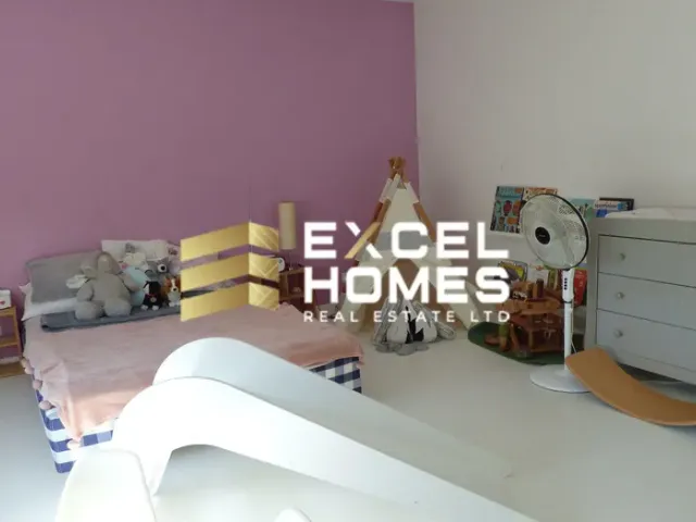 a room with a bed, a desk and a painting 