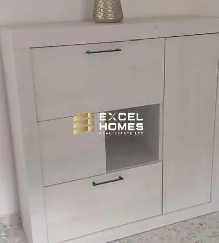 a white clock on a wall with a sign