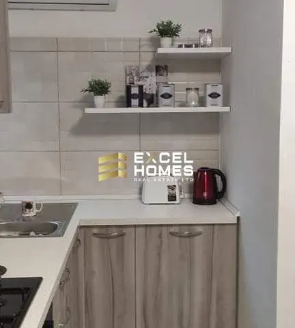 a kitchen with a microwave, refrigerator, and a cupboard