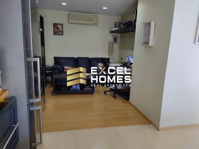 a living room with a couch, a chair, and a door 