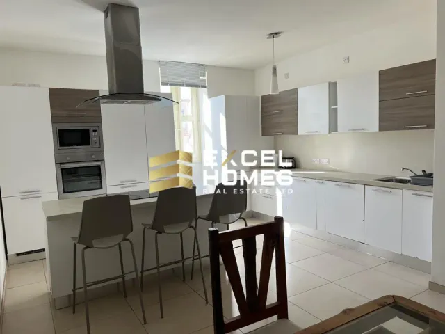 a kitchen with a table and chairs and a refrigerator 
