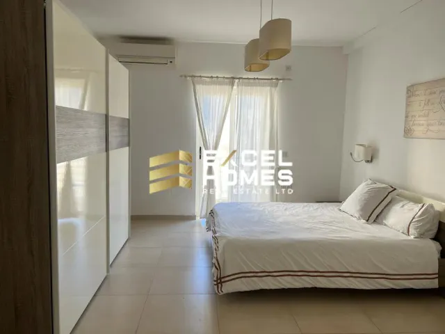 a bedroom with a white bed and a white wall 