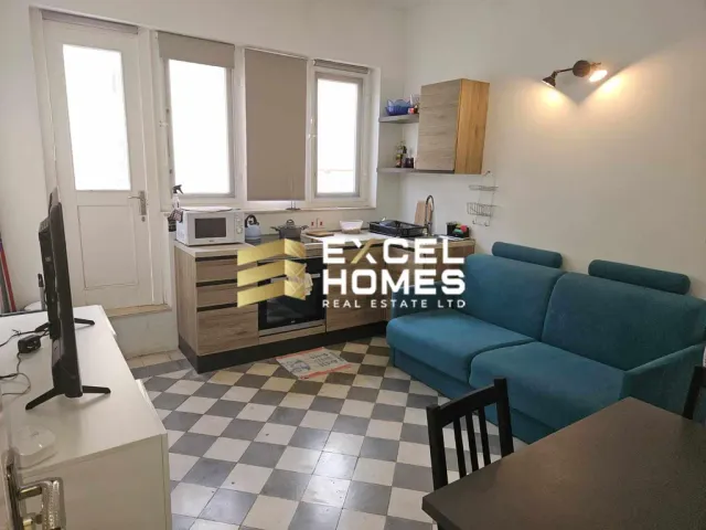 a kitchen with a couch, table, and a microwave 