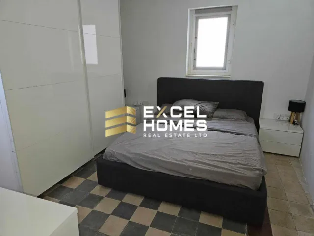 a bed with a white bedspread and a white wall 
