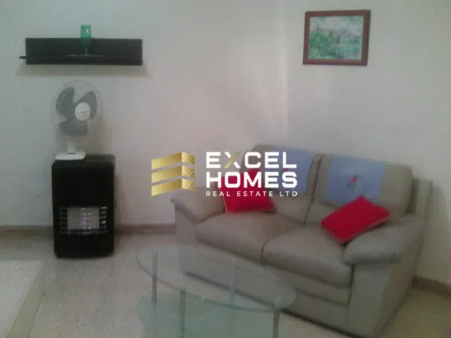 a living room with a couch, coffee table, and a lamp