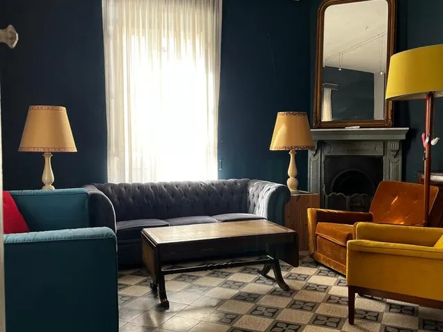 a living room with a couch, chair, and a lamp 