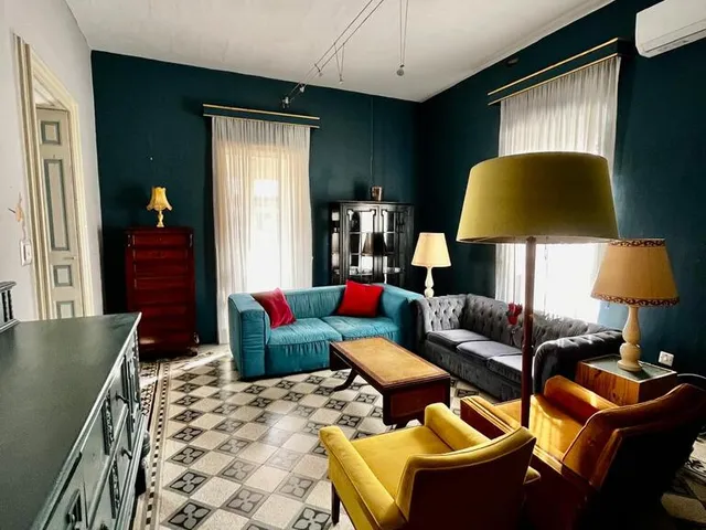 a living room with a couch, chair, and a lamp 