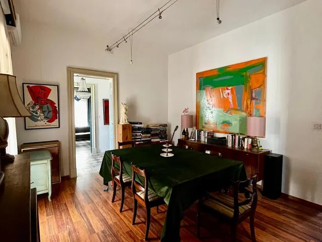 a room with a table, chairs, and a table with a picture on it 