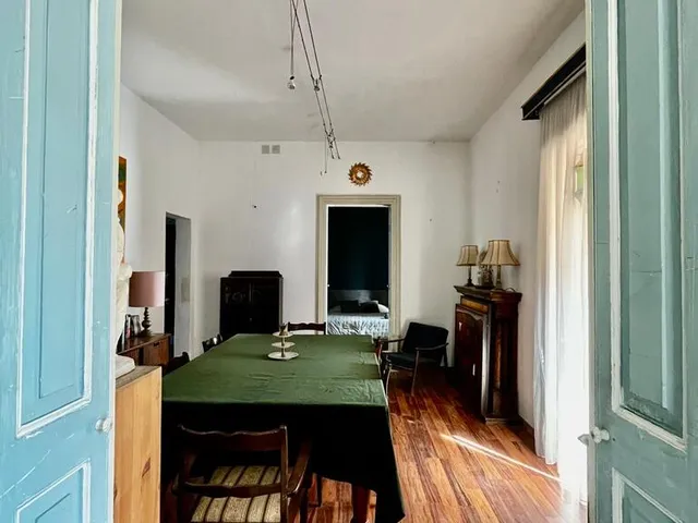 a room with a table, chairs, and a door 