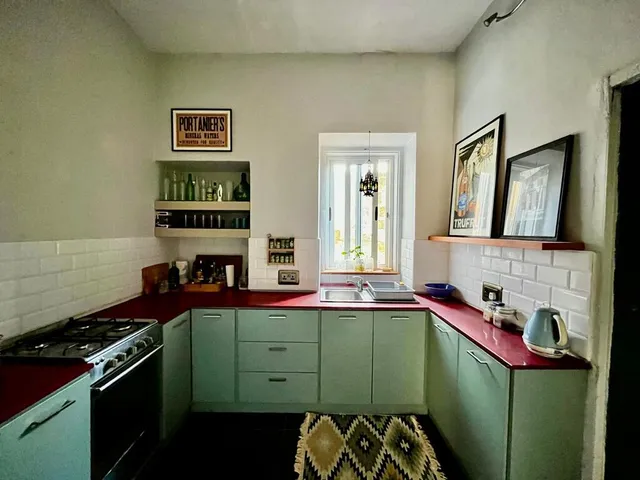 a kitchen with a stove, sink, and cabinets 